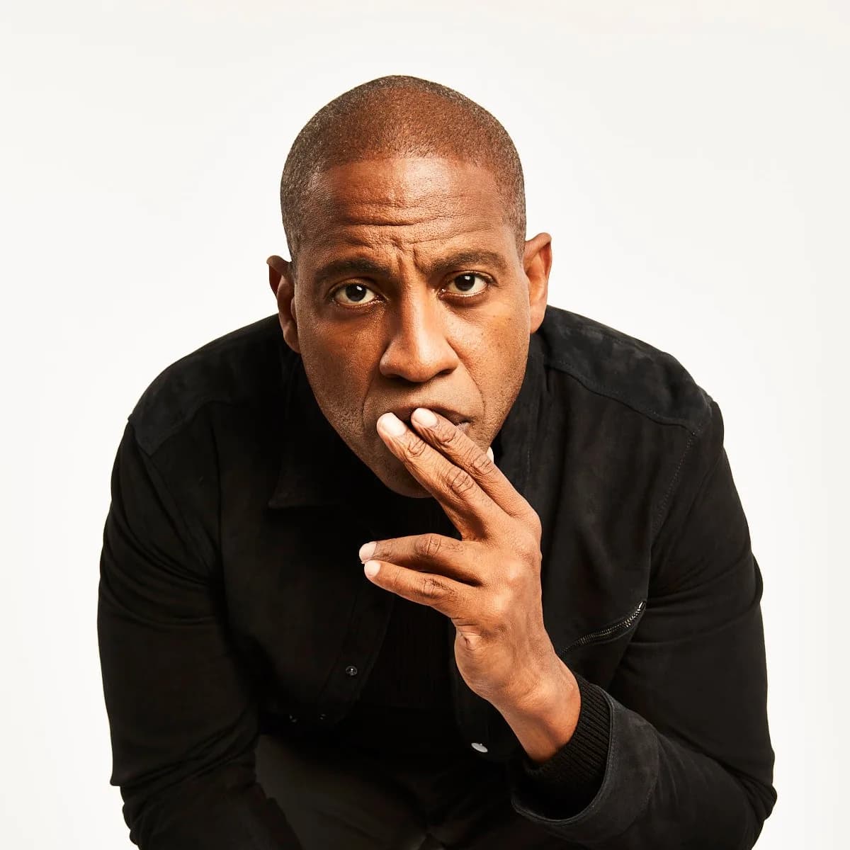 Carlos Watson, hand at his chin, mid-thought